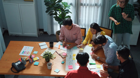 Top view of business people hands making scrum task board to manage workflow in workplace. Diverse...