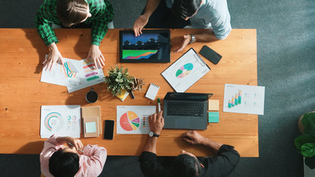 Top view of diverse businesspeople discuss about financial plan at meeting while looking at stock...