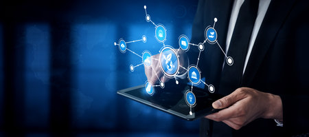 A business professional engages with a tablet showcasing digital icons and data flow, representing...