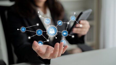 A business professional interacts with a smartphone while showcasing a digital network of...