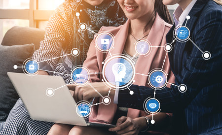 A group of three professionals collaborates over a laptop, surrounded by a digital cloud network...