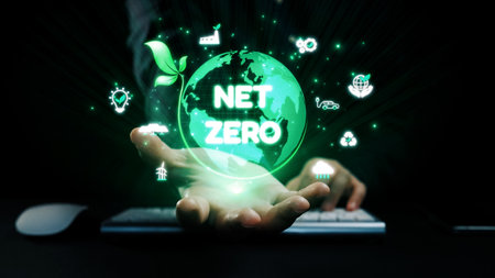 A hand presents a glowing green globe symbolizing net zero goals, merging technology and sustainability in a dark setting, highlighting global environmental action.の写真素材