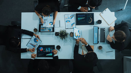 Top down aerial view of business people discussing about financial strategy on table with document and tablet display investment statistic at meeting. Diverse team brainstorm about plan. Directorate.の写真素材