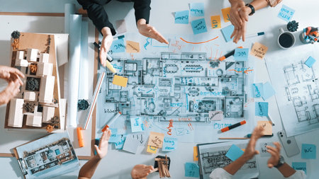 Top view of smart project manager clapping hands to celebrate successful project. Aerial view of skilled architect engineer brainstorming about interior construction. Team work, unity.の写真素材