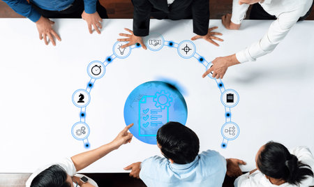 A modern office scene where professionals engage in a collaborative meeting, leveraging digital icons to discuss project management and workflow strategies effectively.の写真素材