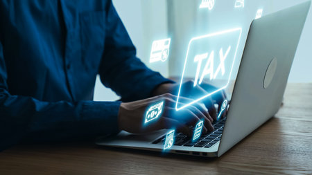 Close-Up of Hands Typing on Laptop with Digital Tax Icons and Symbols Floating Above, Symbolizing Modern Online Tax Filing and Financial Management.の写真素材