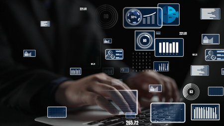 A focus on hands typing on a laptop with floating digital graphics and data visualizations emphasizing technology, analysis, and modern workspace creativity.の写真素材