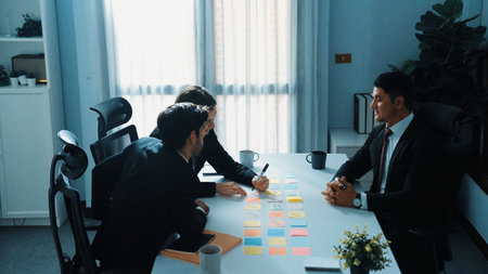 Smart businessman join meeting while marketing team talking plan at table with colorful sticky notes. Group business people brainstorming financial strategy while sitting at meeting room. Directorate.の写真素材