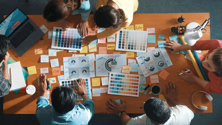 Top down view of designer compare color palettes with laptop and design product. Aerial view of marketing team working together to choose color while discussing about logo graphic design. Symposium.の写真素材