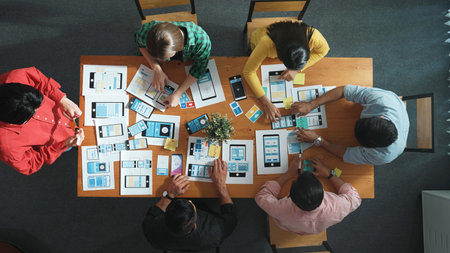 Creative team putting hand together while brainstorm about Ux Ui design mobile phone interface. People planning strategy start up project while making stack of hands at meeting room. Convocation.の写真素材