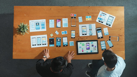 Software developer team holding software icon and discussing about Ux Ui design for mobile phone...