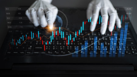 A close-up view of hands interacting with financial charts and data on a laptop keyboard, symbolizing the digital transformation in finance and technology.の写真素材