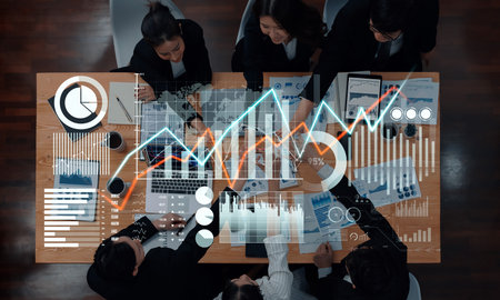 A business team engages in data analysis and strategic planning, surrounded by financial graphs and...