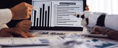 A group of diverse professionals engaged in a business meeting, analyzing product export graphs on a tablet while incorporating technology into their teamwork efforts.の写真素材