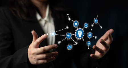 A business professional showcasing innovative technology with hands extended towards interactive icons that symbolize ideas and concepts in a modern digital landscape. Tesselの写真素材