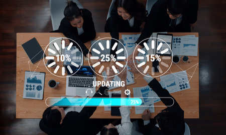 Business team engages in data analysis and updates around a conference table, enhancing collaboration with visual statistics and technology in a modern office environment.の写真素材