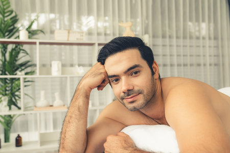 Caucasian man customer enjoying relaxing anti-stress spa massage and pampering with beauty skin recreation leisure in day light ambient salon spa at luxury resort or hotel. Quiescentの写真素材