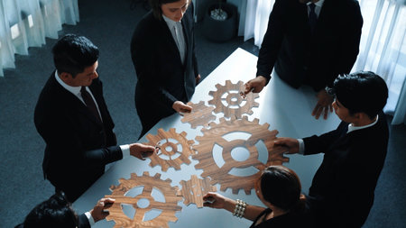 Top view of professional business team bring filled last cog to complete system. Group of smart diverse business people joining gear together at workplace.Show teamwork,unity, working. Directorate.の写真素材
