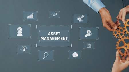 Two hands work together to turn gears representing asset management with various business icons displayed on a gray background for strategy development. Rasterの写真素材