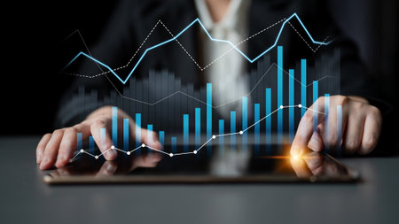 A business professional uses a digital tablet to analyze financial data, showcasing growth trends and investment strategies with vibrant graphs and charts.の写真素材