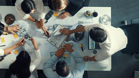 Top view of engineer pointing at turbine engine at meeting table with equipment. Aerial view of professional project manager talking and discussing about electronic generator system.の写真素材