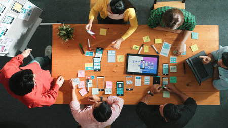 Top view of skilled developer team stick idea about Ux Ui design for mobile phone interface on whiteboard. Smart programmer looking at laptop and present idea about wireframe prototype. Convocation.の写真素材