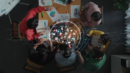 A diverse group of professionals collaborates in a modern office environment, using data visualization and analytical tools to strategize on projects while engaged in discussions. Rasterの写真素材