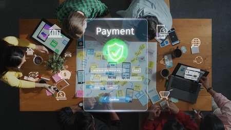 A diverse group of individuals collaborates around a table, focusing on innovative digital payment solutions, symbolizing teamwork in financial technology. Rasterの写真素材
