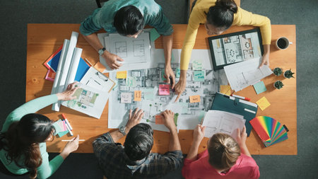 Time lapse of skilled architect hold plan to designer asking idea about building structure. Top down view of professional engineer working and discussing about house plan at meeting room. Symposium.の写真素材