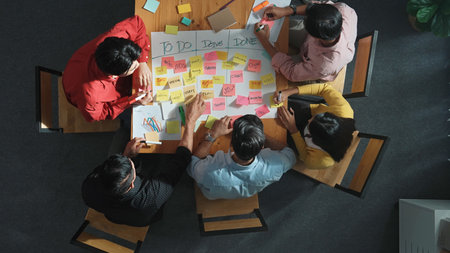 Top view of people writing and making scrum task board while writing marketing and planning strategy at colorful sticky notes. Smart team manage work performance by using kanban board.の写真素材