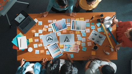 Top down view of smart designer explain and brainstorming idea for logo design and writing concept. Aerial view of business people discuss and talking while using sticky notes sharing idea. Symposium.の写真素材