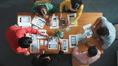 Creative team sitting and discussing while brainstorm about Ux Ui design mobile phone interface. People planning strategy start up project while planning a strategy at business meeting. Convocation.の写真素材