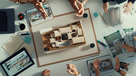 Top view of smart manager clapping hands and putting hands together to celebrate project. Aerial view of architect engineer brainstorming about interior construction. Team work, unity.の写真素材
