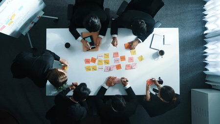 Top down aerial view of professional business people writing and sharing marketing idea on sticky...