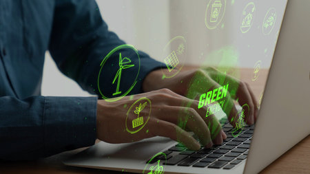 A close-up view of hands typing on a laptop, surrounded by glowing icons representing green energy...