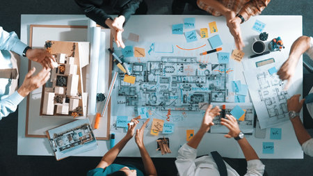 Top view of smart manager clapping hands and putting hands together to celebrate project. Aerial view of architect engineer brainstorming about interior construction. Team work, unity.の写真素材