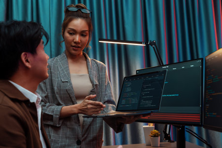 Serious of IT developers discussing intelligent website development coder system running data online two screens with laptop showing information network at neon light room at modern office. Infobahn.の写真素材
