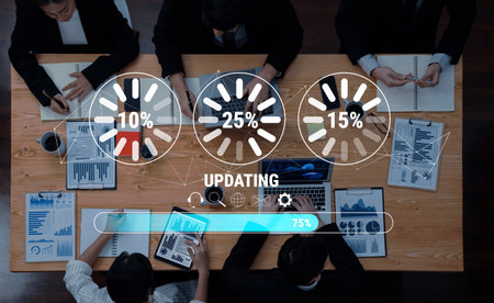 A top-down view of a business meeting with professionals reviewing documents and screens, showcasing...