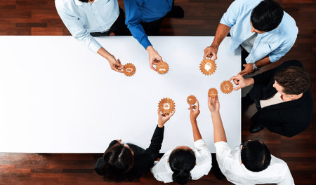 A top-down view of a diverse team engaged in a collaborative session, piecing together gear elements...