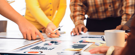 A diverse team collaborates in a bright office, analyzing data and discussing strategies. Colorful...