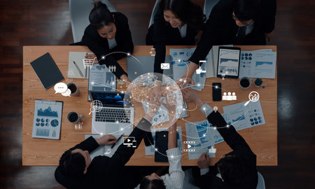 A group of professionals engaged in a collaborative business meeting, utilizing technology for data visualization and global connectivity in a modern office setting.の写真素材