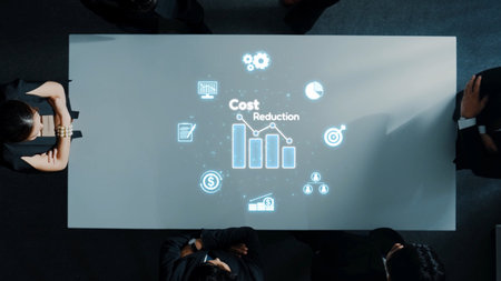 A business team engages in a detailed analysis of cost reduction strategies, with dynamic graphs and icons projected on a sleek conference table. Rasterの写真素材