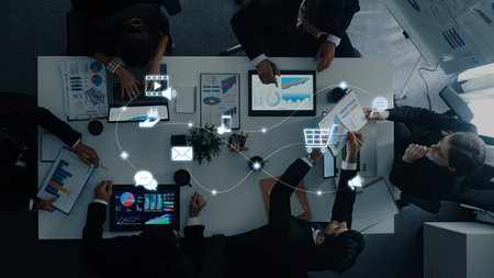 Diverse professionals collaborate in a modern office setting using digital devices, presenting data visualizations, and fostering teamwork for strategic business decisions.の写真素材