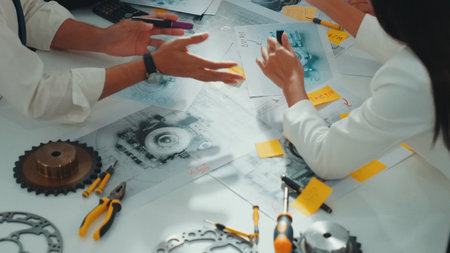 Top view of engineer pointing at turbine engine at meeting table with equipment. Aerial view of professional project manager talking and discussing about electronic generator system.の写真素材