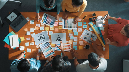 Top down view of smart designer explain and brainstorming idea for logo design and writing concept. Aerial view of business people discuss and talking while using sticky notes sharing idea. Symposium.の写真素材