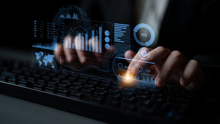A professional hands-on keyboard interacting with futuristic projections of data metrics, charts,...