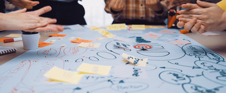 Energetic team collaboration session captured with hands in motion over a detailed mind map....