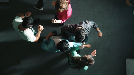 Top down view of smart business team working together and putting hands together. Aerial view of group of skilled business people brainstorming and making stack of hands at meeting room. Symposium.の写真素材