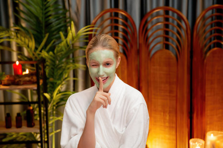 Serene ambiance of spa salon, woman customer indulges in rejuvenating with luxurious face cream massage with warm lighting candle. Facial skin treatment and beauty care concept.の写真素材