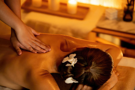 Caucasian woman customer enjoying relaxing anti-stress spa massage and pampering with beauty skin recreation leisure in warm candle lighting ambient salon spa at luxury resort or hotel. Quiescentの写真素材